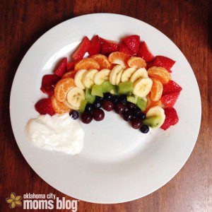 Arrange different fruits to form a rainbow with a yogurt cloud.